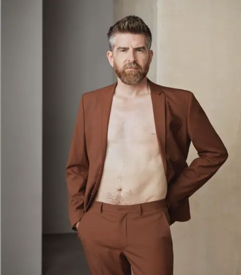 Phil Alderson modelling a rust-coloured suit