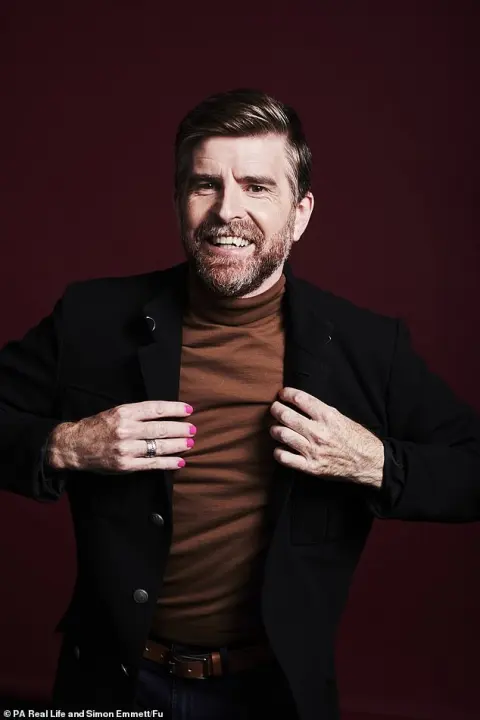 Phil Alderson in a dark jacket against a red background