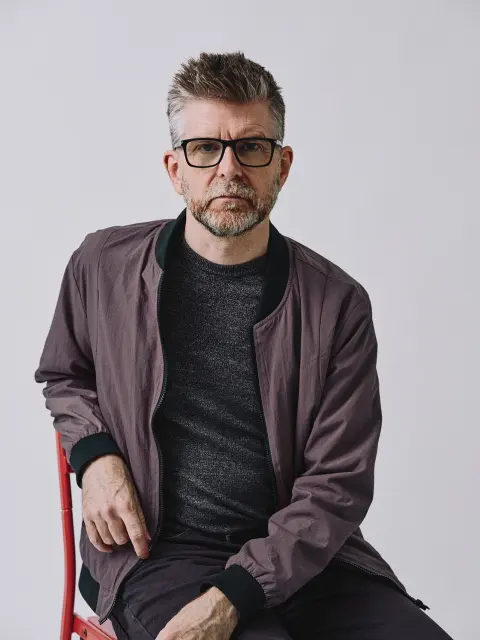 Phil Alderson seated in a studio portrait
