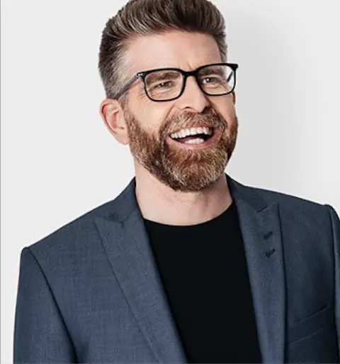 Phil Alderson smiling in a navy blazer